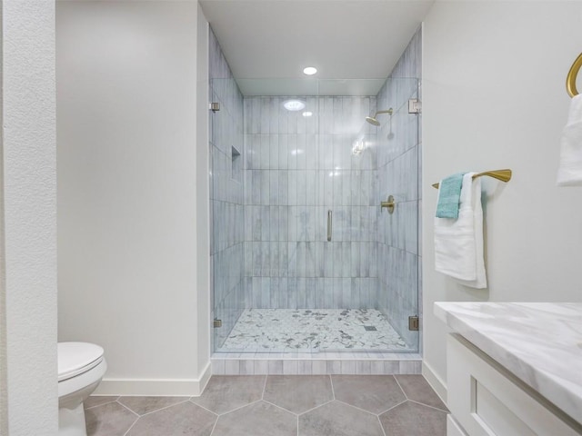 bathroom featuring tile patterned flooring, vanity, a shower with door, and toilet