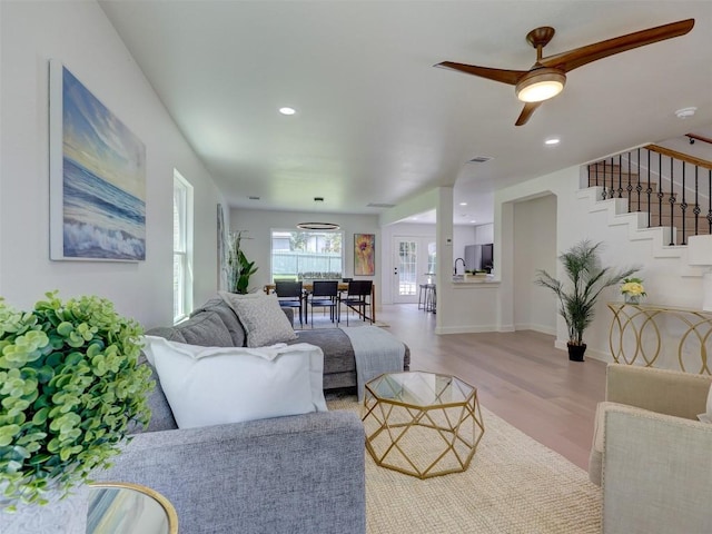 living room featuring ceiling fan and light wood-type flooring