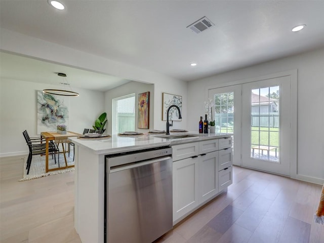 kitchen featuring sink, decorative light fixtures, stainless steel dishwasher, a kitchen island with sink, and white cabinets