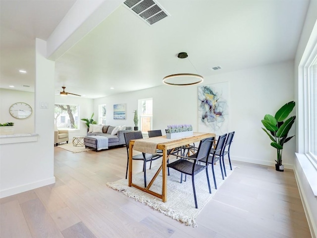 dining space with light hardwood / wood-style flooring, a wealth of natural light, and ceiling fan