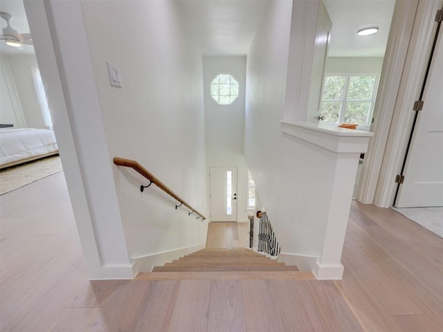 stairs featuring hardwood / wood-style floors and a high ceiling