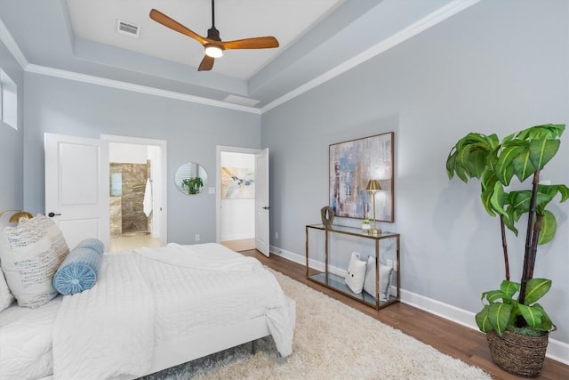 bedroom featuring crown molding, hardwood / wood-style flooring, a raised ceiling, and ceiling fan