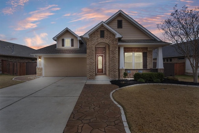 view of front of home featuring a yard, a garage, and a porch