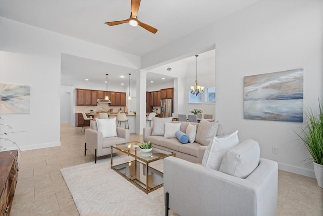 living room with ceiling fan with notable chandelier and light tile patterned floors