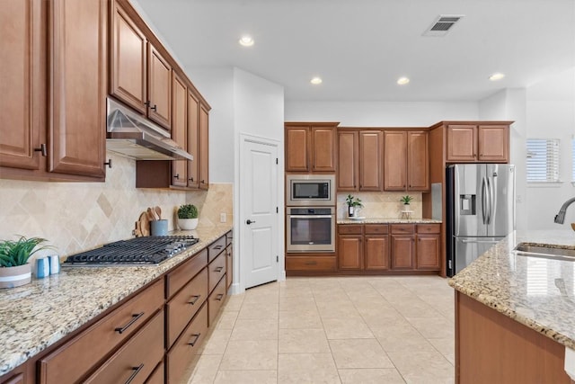 kitchen featuring sink, backsplash, light tile patterned floors, light stone counters, and stainless steel appliances