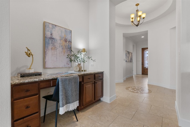 tiled home office with built in desk, a notable chandelier, and a tray ceiling