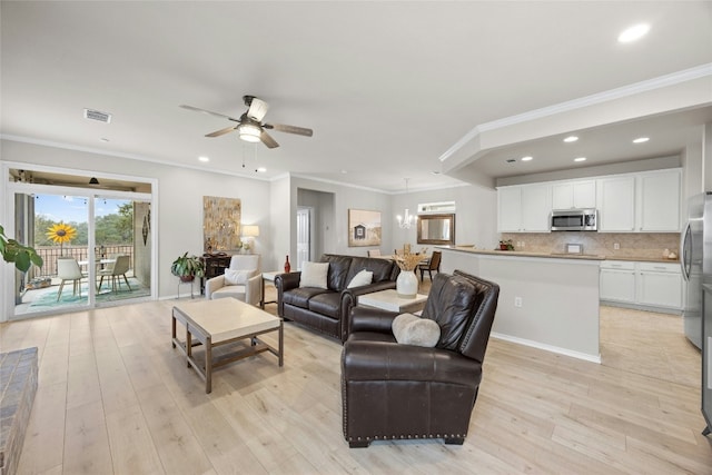 living room with ceiling fan with notable chandelier, light hardwood / wood-style flooring, and ornamental molding