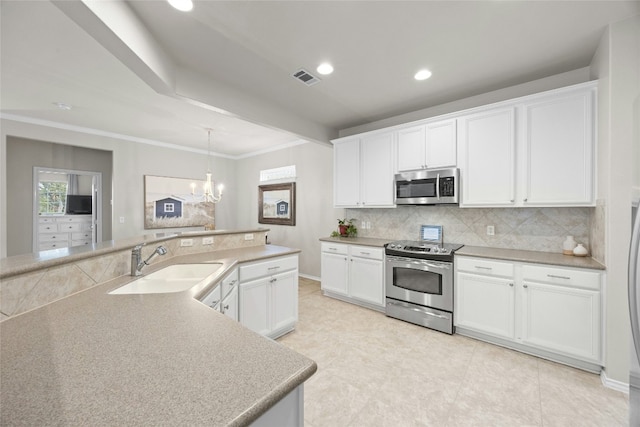 kitchen with pendant lighting, sink, appliances with stainless steel finishes, tasteful backsplash, and white cabinets