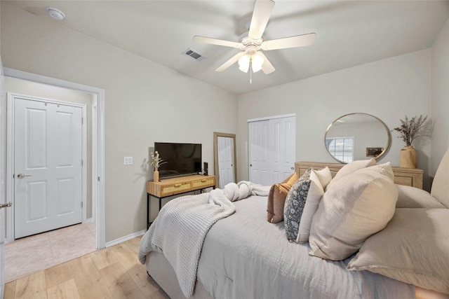 bedroom featuring ceiling fan, light hardwood / wood-style floors, and a closet