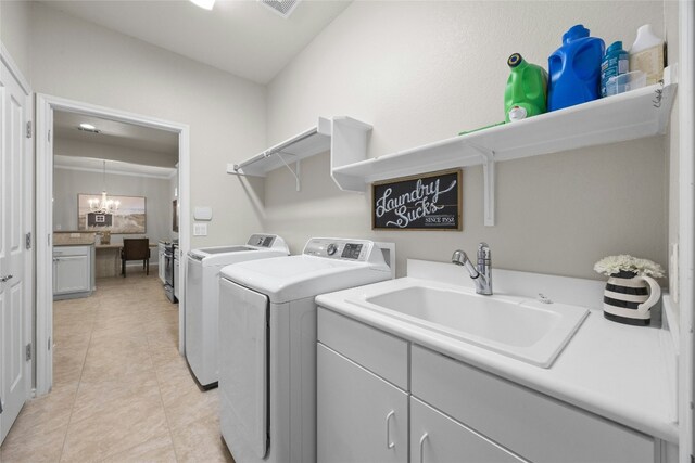 116 Granite Peak Cv, Georgetown, TX 78633 - washroom with cabinet space, a sink, a notable chandelier, light tile patterned flooring, and washer and dryer