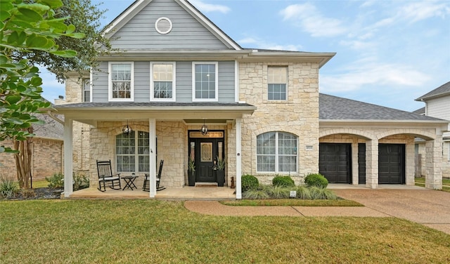 view of front of house featuring a garage, a front lawn, and covered porch