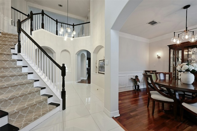 interior space with an inviting chandelier, ornamental molding, and wood-type flooring