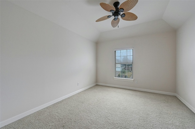 carpeted spare room featuring lofted ceiling and ceiling fan