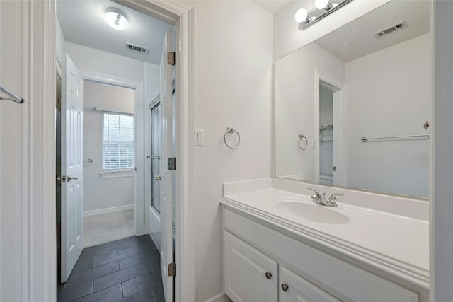 bathroom with vanity and shower / bath combination with glass door