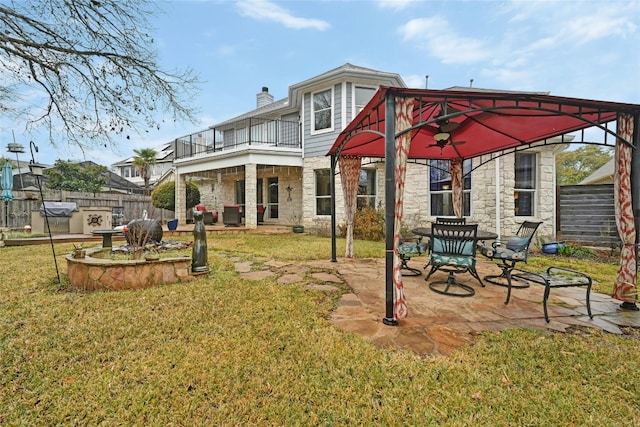 back of house featuring a gazebo, a lawn, a patio, and a balcony