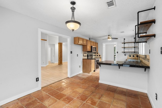 kitchen featuring a breakfast bar, sink, appliances with stainless steel finishes, kitchen peninsula, and pendant lighting