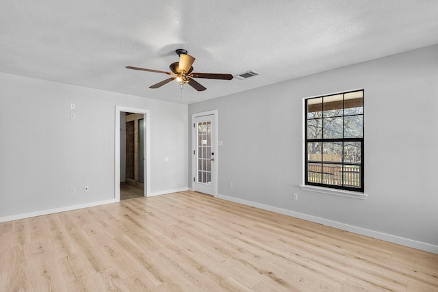 spare room with a textured ceiling, light hardwood / wood-style flooring, and ceiling fan