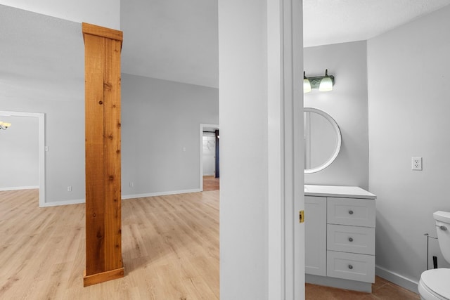 bathroom with hardwood / wood-style flooring, vanity, and toilet