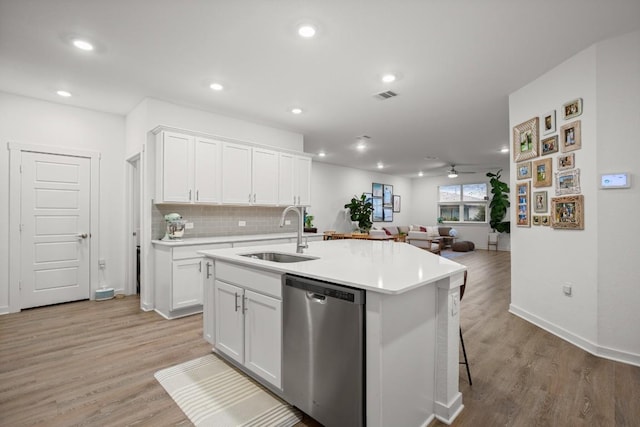 kitchen with white cabinetry, dishwasher, sink, and a center island with sink