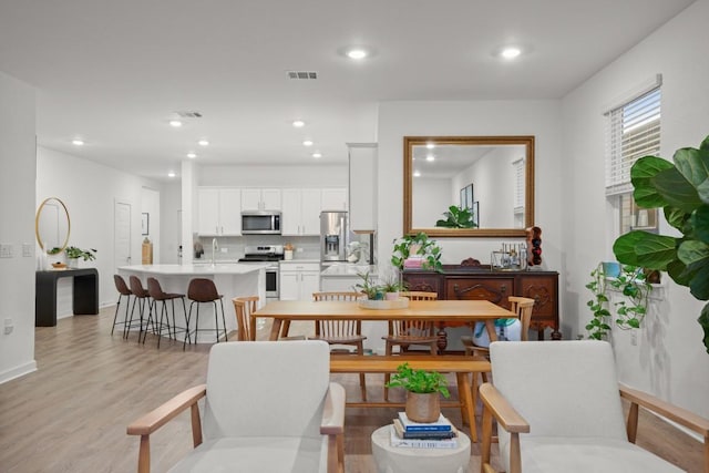 dining room featuring sink and light hardwood / wood-style flooring