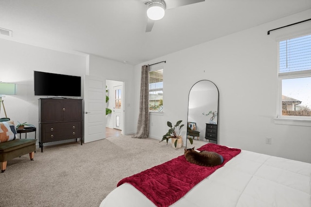 bedroom featuring multiple windows, light colored carpet, and ceiling fan