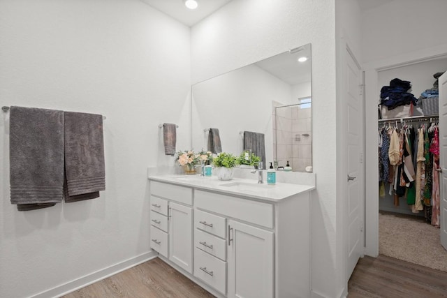 bathroom with hardwood / wood-style flooring, vanity, and walk in shower