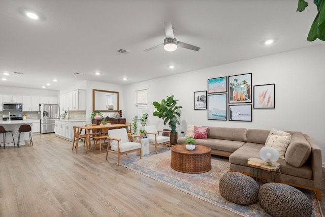 living room featuring ceiling fan and light hardwood / wood-style floors