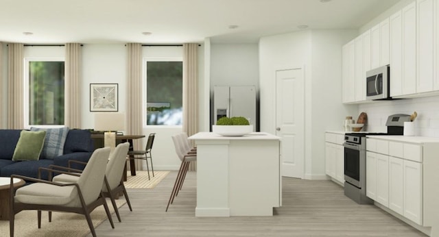 kitchen with a center island with sink, light wood-type flooring, stainless steel appliances, and white cabinets