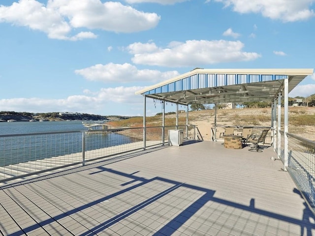 dock area with a fire pit and a water view