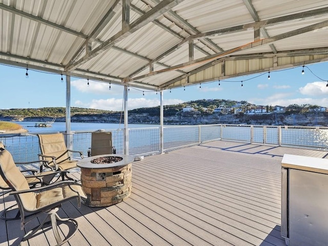 view of dock with a deck with water view and a fire pit