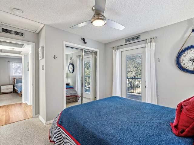 carpeted bedroom with multiple windows, access to exterior, and a textured ceiling