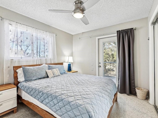 carpeted bedroom with multiple windows, ceiling fan, access to exterior, and a textured ceiling