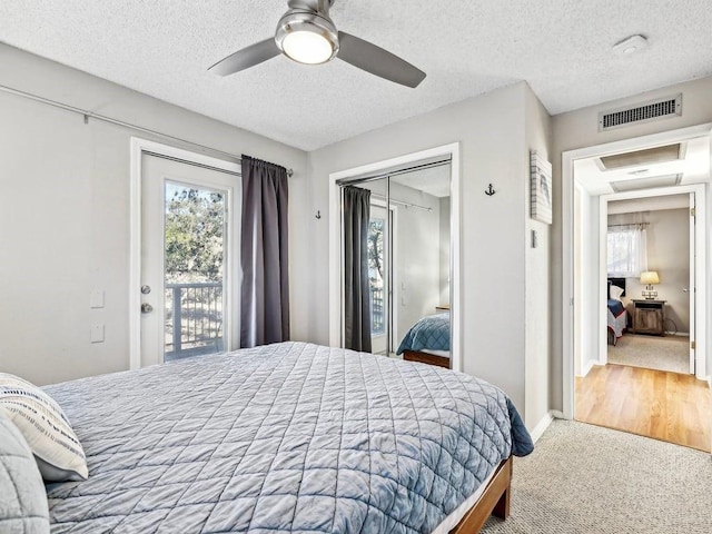 carpeted bedroom with a textured ceiling, access to outside, a closet, and ceiling fan