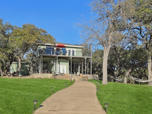 rear view of property featuring a wooden deck and a yard