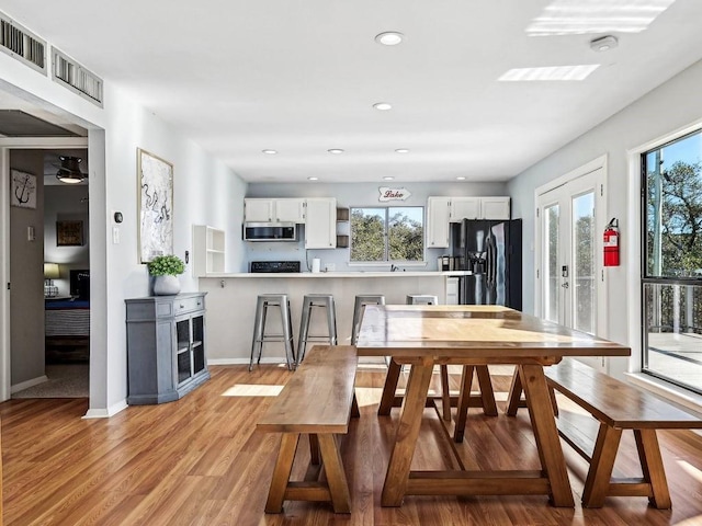 dining room featuring a wealth of natural light and light hardwood / wood-style flooring