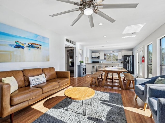 living room with hardwood / wood-style flooring and ceiling fan