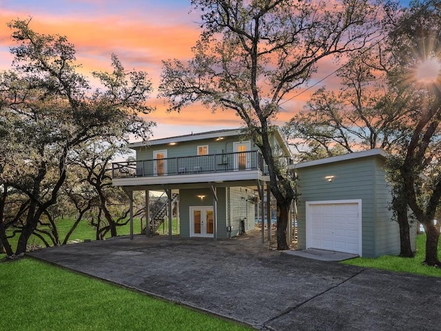 view of front of home featuring a garage, a balcony, and french doors