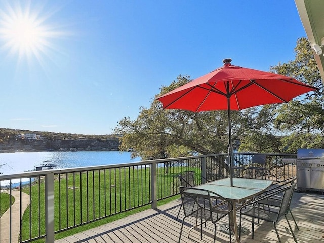 deck featuring a water view, area for grilling, and a yard