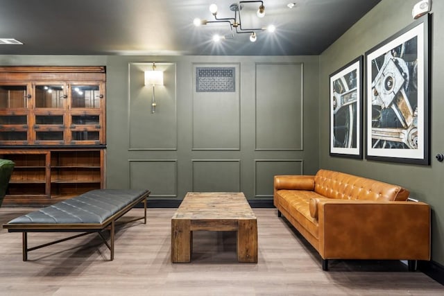 sitting room featuring wood-type flooring and a notable chandelier