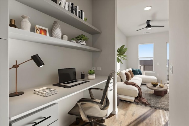 office space with hardwood / wood-style floors, built in desk, and ceiling fan