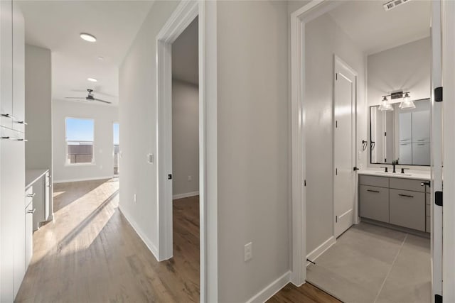 hallway featuring sink and light wood-type flooring