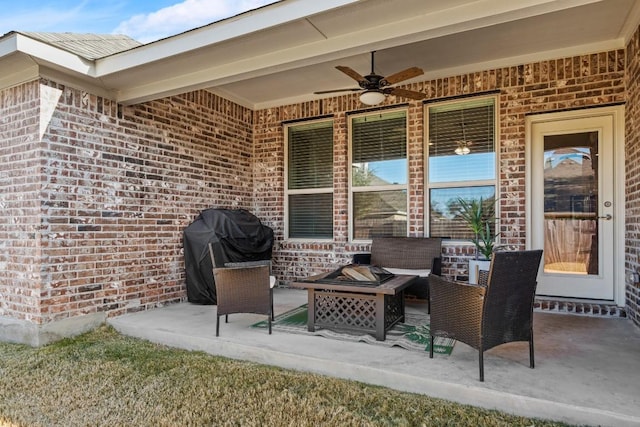 view of patio featuring area for grilling, ceiling fan, and a fire pit