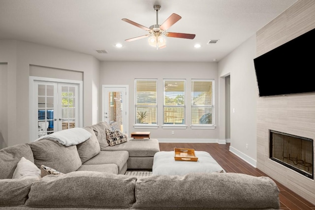 living room featuring a healthy amount of sunlight, dark wood-type flooring, and french doors