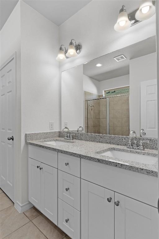 bathroom featuring vanity, a shower with door, and tile patterned floors