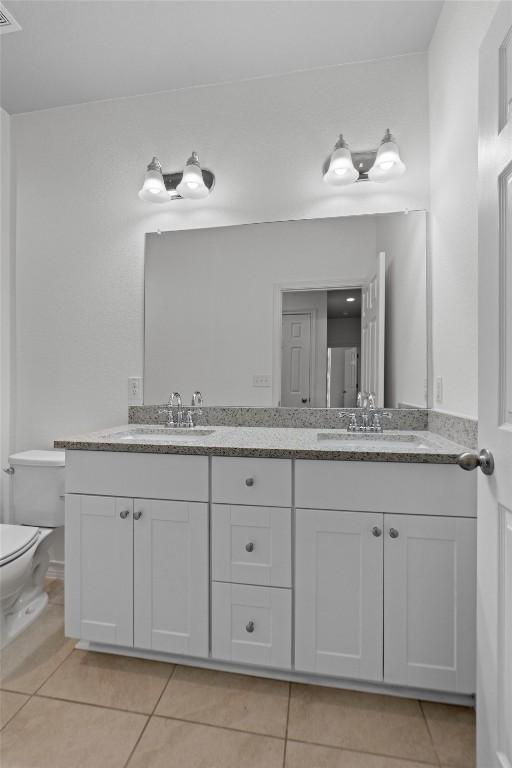 bathroom featuring vanity, toilet, and tile patterned flooring