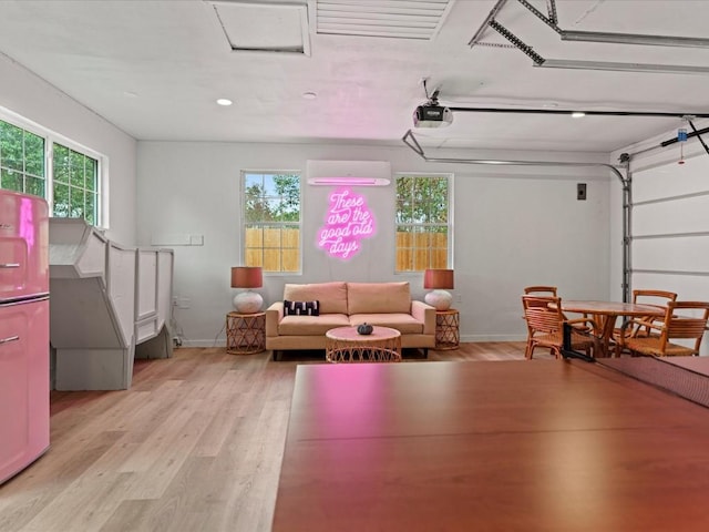 playroom featuring a wall mounted AC and light wood-type flooring