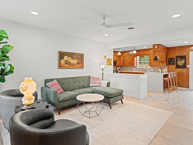 living room with ceiling fan and light hardwood / wood-style flooring