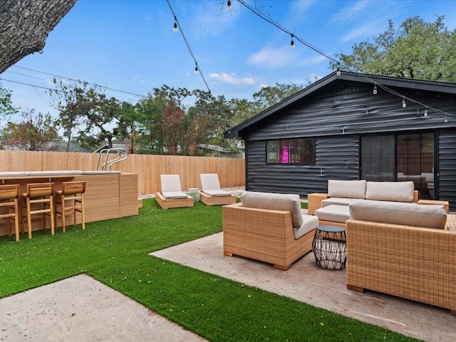 back of property featuring an outdoor hangout area, a lawn, a patio, and exterior bar