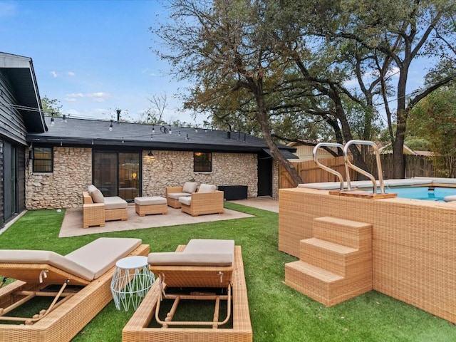 back of house with an outdoor living space, a yard, a fenced in pool, and a patio