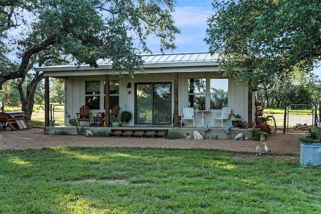 rear view of property featuring a lawn